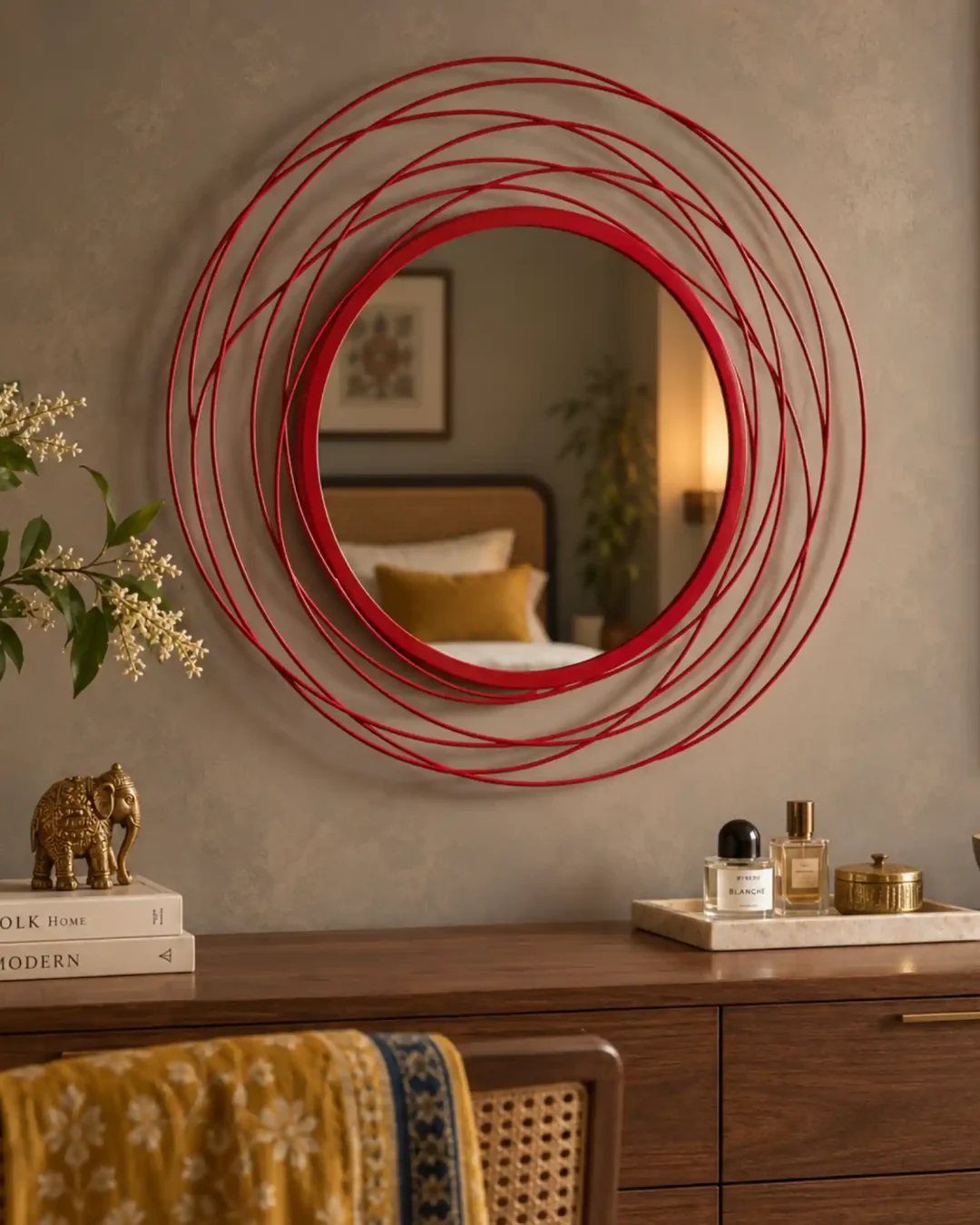 Red round wall mirror above dark wood console